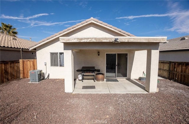 rear view of house with central AC unit and a patio area