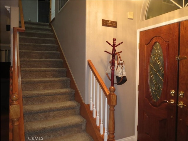 entrance foyer featuring stairway and baseboards