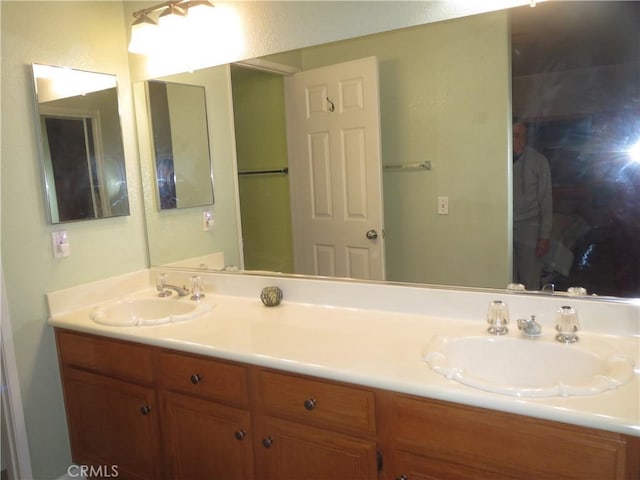 full bathroom with a sink and double vanity