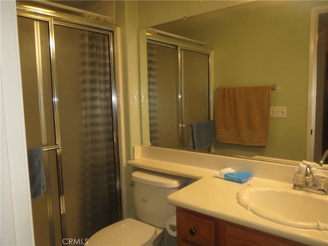 full bathroom with a stall shower, toilet, and vanity