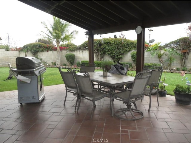 view of patio featuring outdoor dining space, a fenced backyard, and a grill