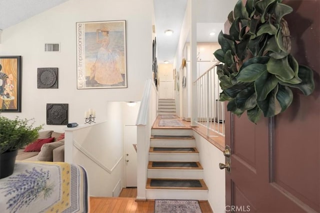 staircase featuring visible vents and wood finished floors