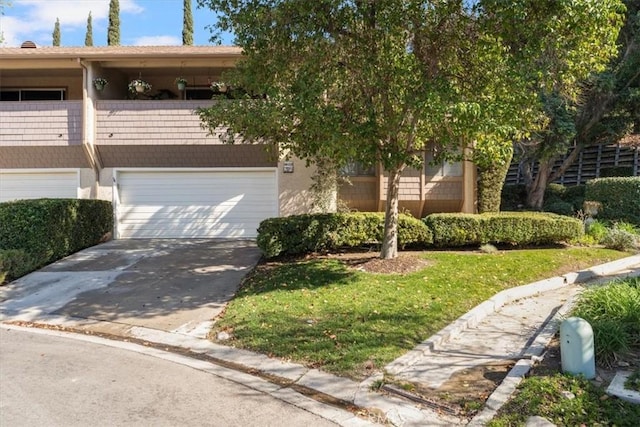 view of front of home with a garage, concrete driveway, and stucco siding