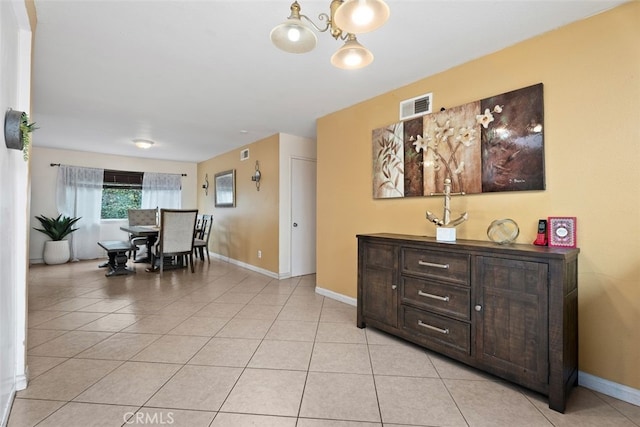 dining area featuring light tile patterned floors and a notable chandelier