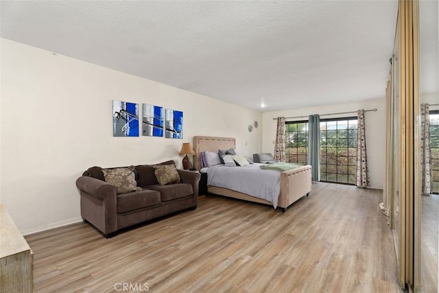 bedroom with light hardwood / wood-style flooring and a textured ceiling