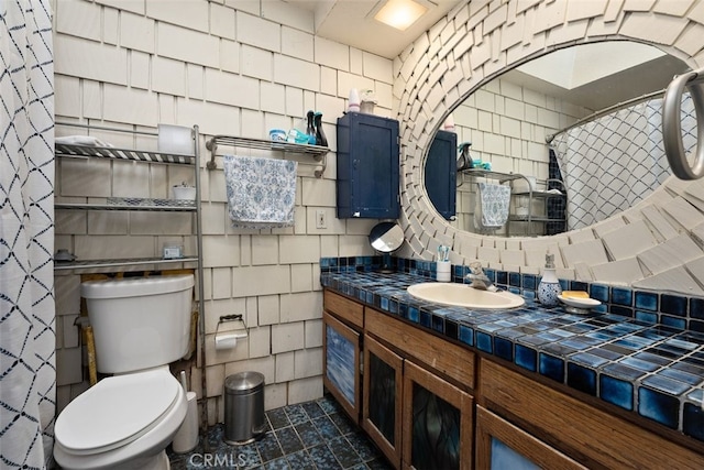 bathroom with toilet, tasteful backsplash, tile walls, vanity, and tile patterned flooring