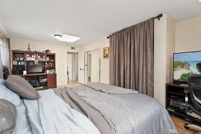 bedroom featuring a skylight and light wood-type flooring