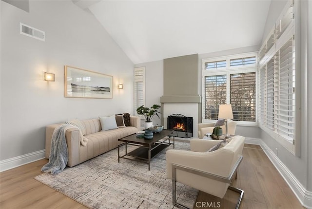 living room featuring light hardwood / wood-style flooring and high vaulted ceiling