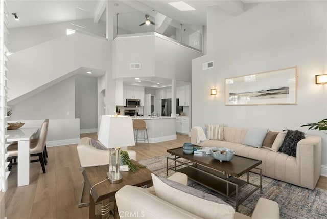 living room with lofted ceiling with beams and light hardwood / wood-style floors