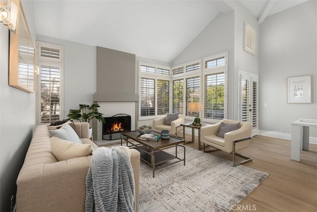 living room with high vaulted ceiling and light wood-type flooring