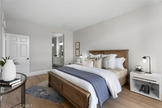 bedroom featuring connected bathroom and light wood-type flooring