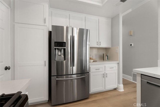 kitchen featuring stainless steel appliances, white cabinets, and light wood-type flooring