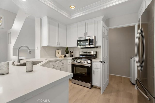 kitchen with appliances with stainless steel finishes, sink, and white cabinets