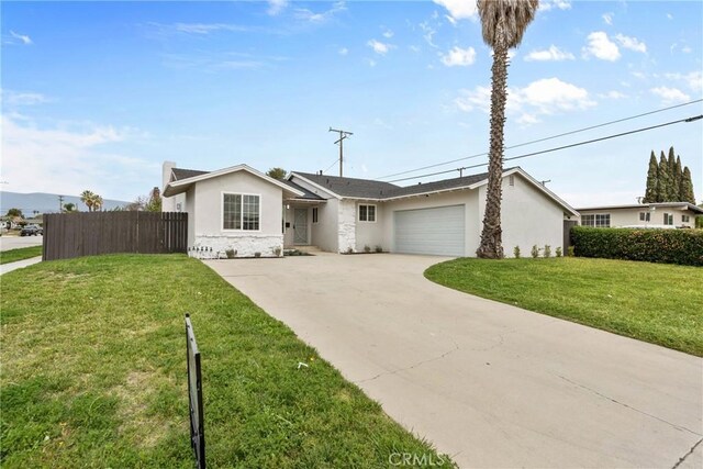 5594 Denver St, Montclair, CA 91763 - ranch-style house with driveway, fence, an attached garage, a front yard, and stucco siding