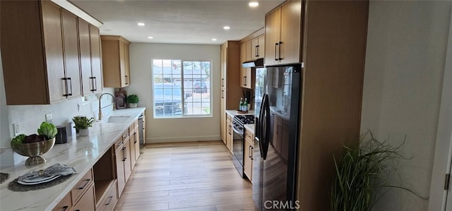 5594 Denver St, Montclair, CA 91763 - kitchen with a sink, light wood-type flooring, range with gas stovetop, black fridge with ice dispenser, and under cabinet range hood