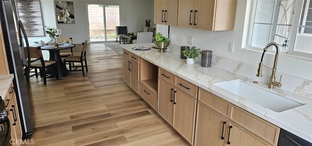 5594 Denver St, Montclair, CA 91763 - kitchen featuring light stone counters, a sink, light brown cabinetry, light wood-style flooring, and freestanding refrigerator