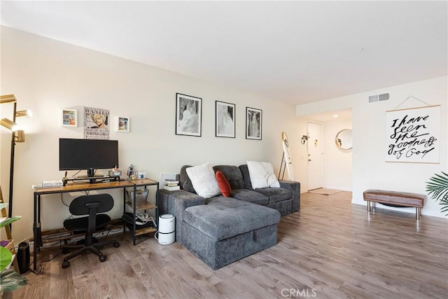 living area featuring visible vents and wood finished floors