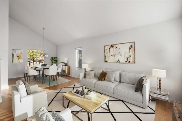 living room featuring high vaulted ceiling and light hardwood / wood-style floors