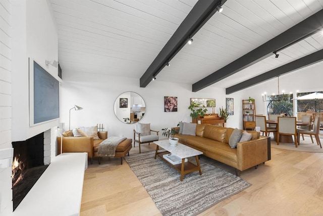 living room with beam ceiling, light wood-type flooring, a notable chandelier, and a fireplace