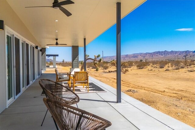 view of patio featuring ceiling fan and a mountain view