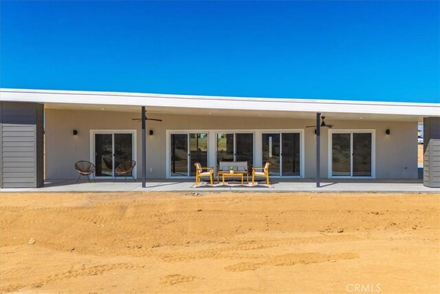 rear view of house with ceiling fan, an outdoor hangout area, and a patio area