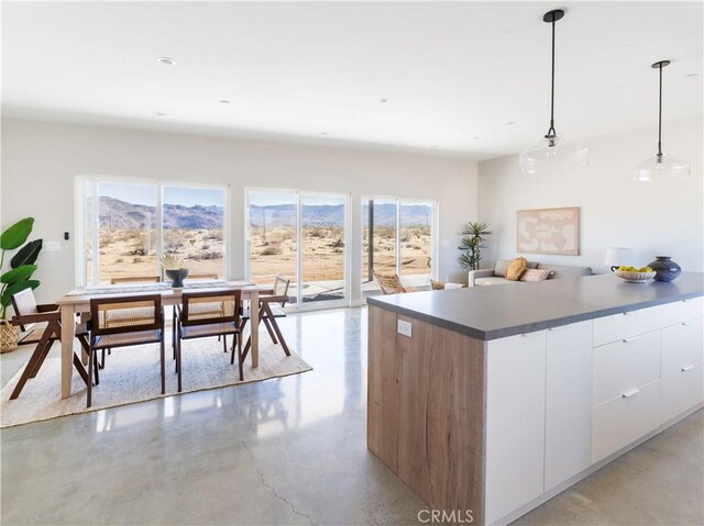 kitchen with pendant lighting, a mountain view, and white cabinets