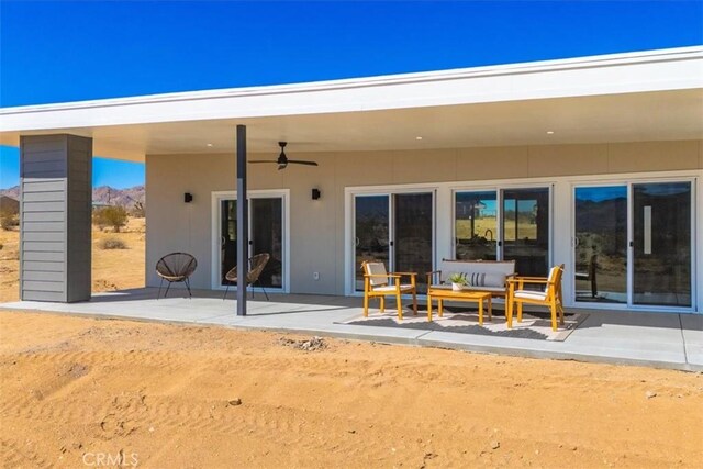 rear view of property featuring ceiling fan and a patio area