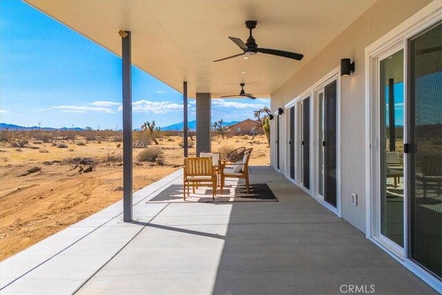 view of patio with ceiling fan and a mountain view