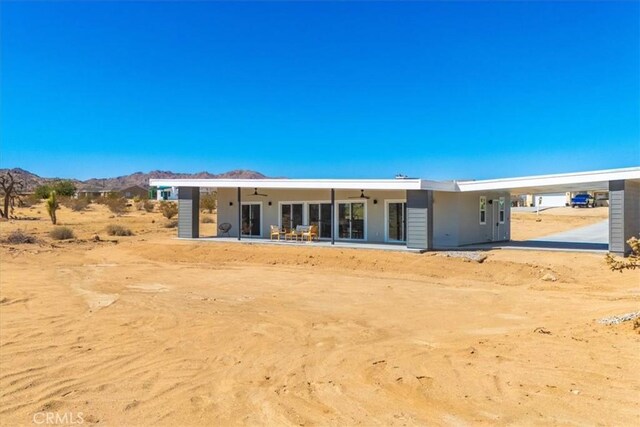 back of property featuring a mountain view and ceiling fan