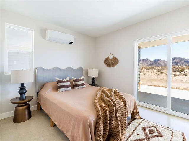 bedroom with a mountain view, a wall unit AC, and access to exterior