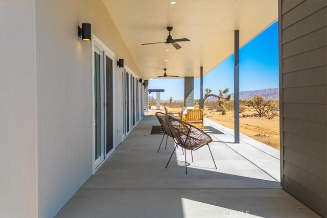 view of patio / terrace with a mountain view and ceiling fan