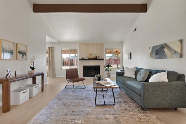 living area featuring baseboards, a textured ceiling, a fireplace, high vaulted ceiling, and beam ceiling