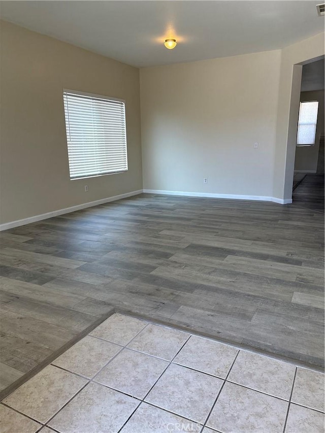 spare room featuring light tile patterned floors and a healthy amount of sunlight