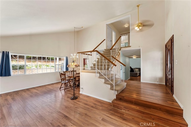 entrance foyer featuring stairs, a towering ceiling, and hardwood / wood-style flooring