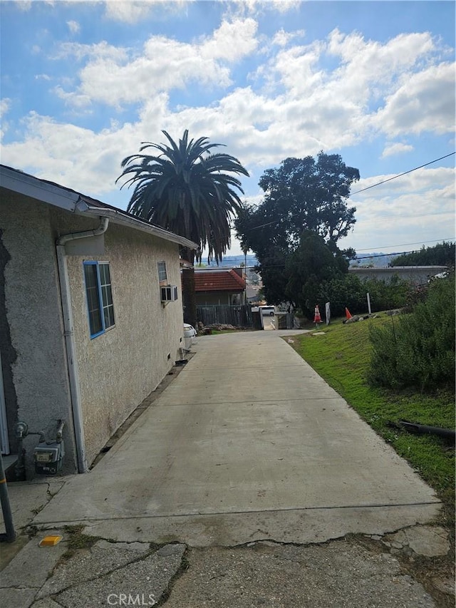 view of side of home featuring a patio and a lawn