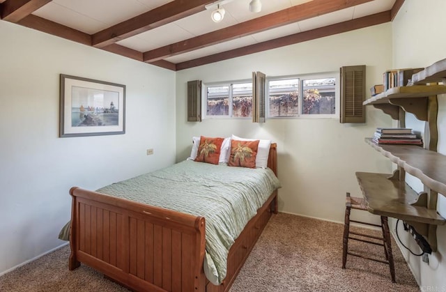 bedroom with beamed ceiling and carpet floors