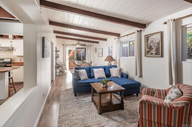 living room featuring ceiling fan, light wood-type flooring, wooden ceiling, and beam ceiling