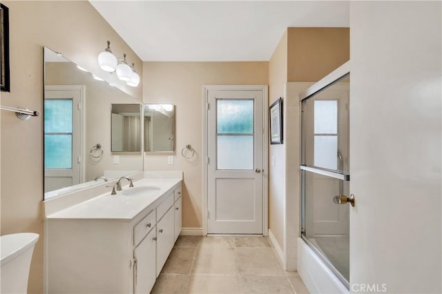 bathroom with tile patterned floors, vanity, and shower / bath combination with glass door