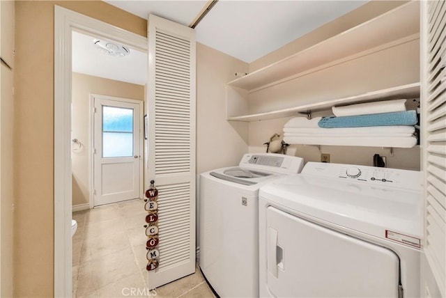 laundry room featuring washing machine and dryer and light tile patterned flooring