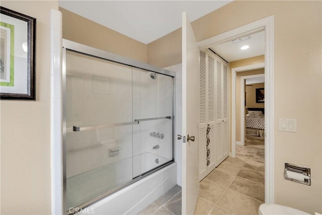 bathroom with tile patterned flooring, enclosed tub / shower combo, and toilet