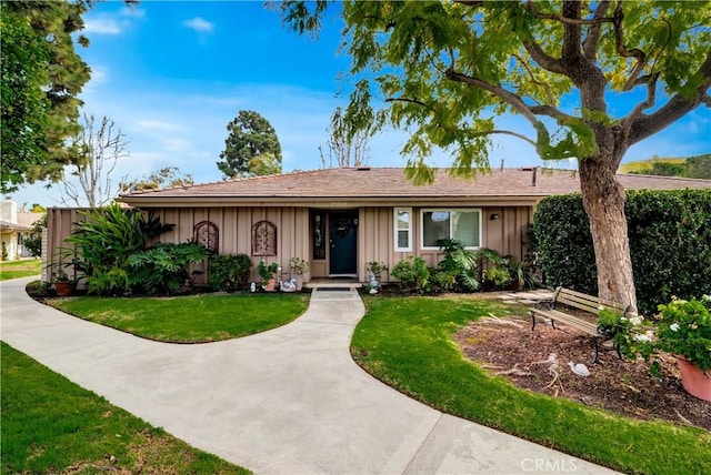 single story home featuring a front lawn