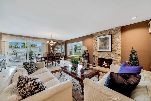 living room with plenty of natural light, a fireplace, and a notable chandelier