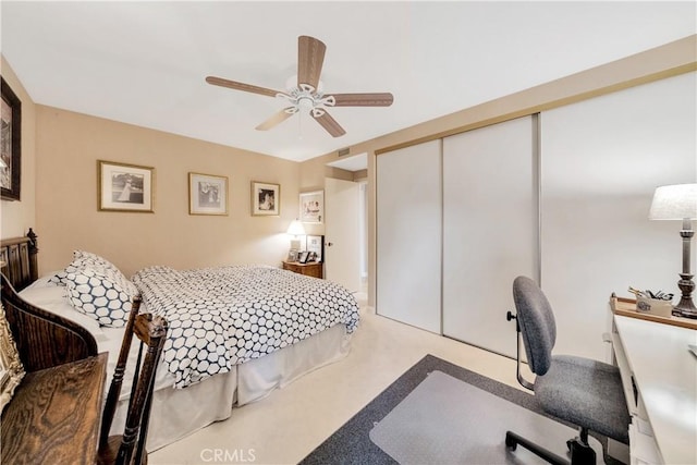 carpeted bedroom featuring ceiling fan and a closet