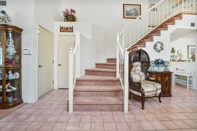 1308 Pleasant Valley Ave, Banning, CA 92220 - stairs featuring tile patterned flooring, visible vents, and a high ceiling