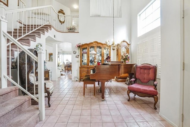 1308 Pleasant Valley Ave, Banning, CA 92220 - interior space with light tile patterned floors, arched walkways, an inviting chandelier, a high ceiling, and stairs