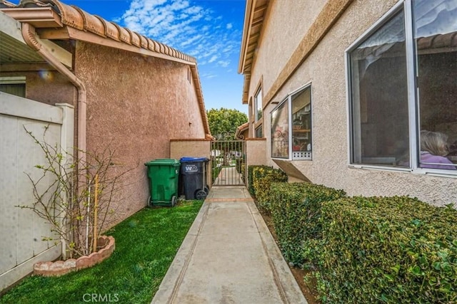 1308 Pleasant Valley Ave, Banning, CA 92220 - view of home's exterior featuring a gate, fence, and stucco siding