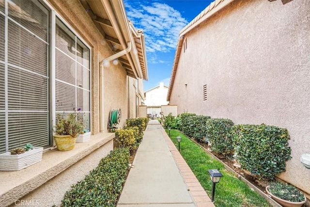 1308 Pleasant Valley Ave, Banning, CA 92220 - view of side of property with a gate and stucco siding