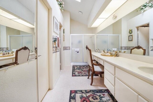 1308 Pleasant Valley Ave, Banning, CA 92220 - bathroom with vaulted ceiling with skylight, visible vents, a shower stall, tile patterned floors, and double vanity