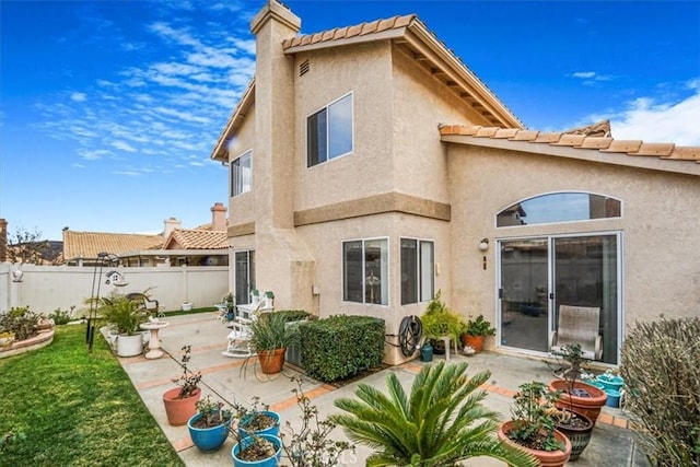 1308 Pleasant Valley Ave, Banning, CA 92220 - rear view of house featuring stucco siding, a patio, a chimney, and fence