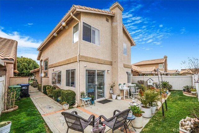 1308 Pleasant Valley Ave, Banning, CA 92220 - back of property with stucco siding, a lawn, a gate, a patio area, and a fenced backyard